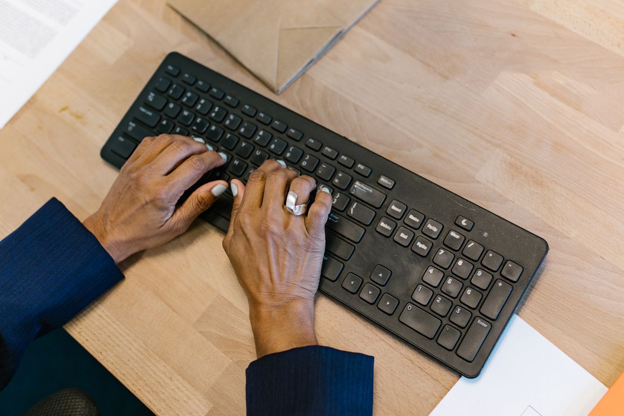 Services Overhead shot of hands typing on a keyboard in an office setting, highlighting productivity and technology.